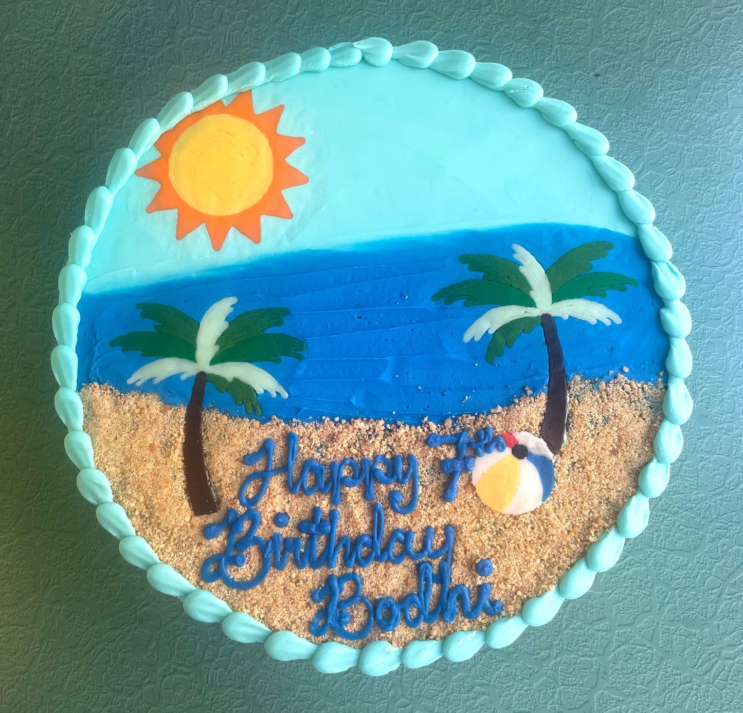 Birthday cake with beach scene decoration on a blue background