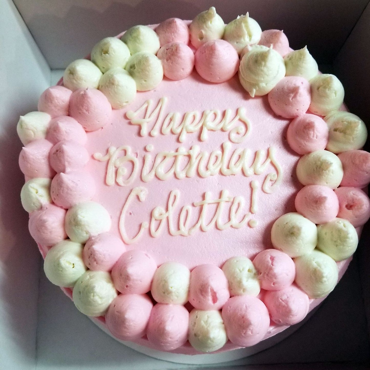Pink birthday cake with meringue decorations and 'Happy Birthday Colette!' text.