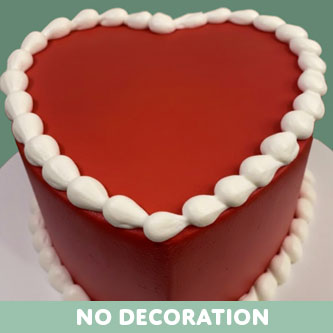 Heart-shaped red cake with white frosting on a green background