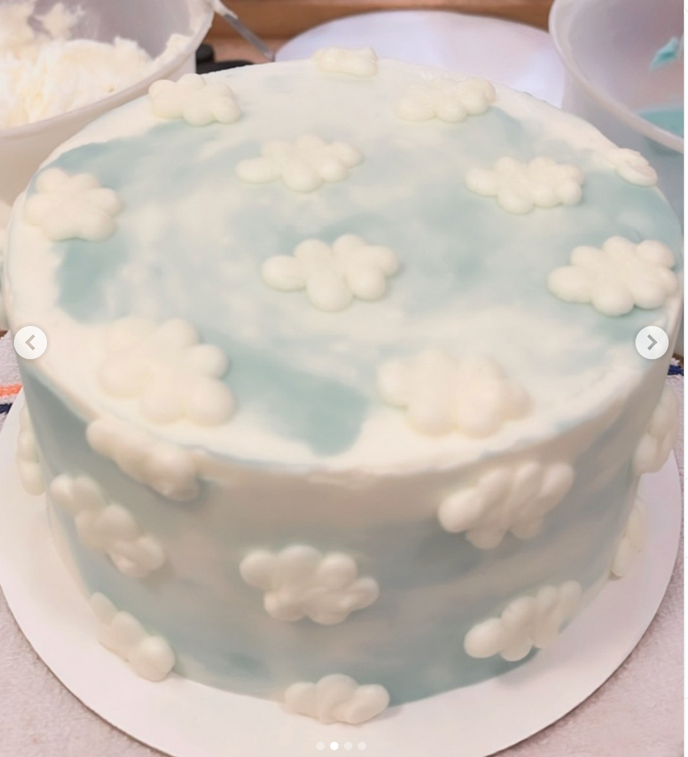 Cake with cloud decorations on a light blue background